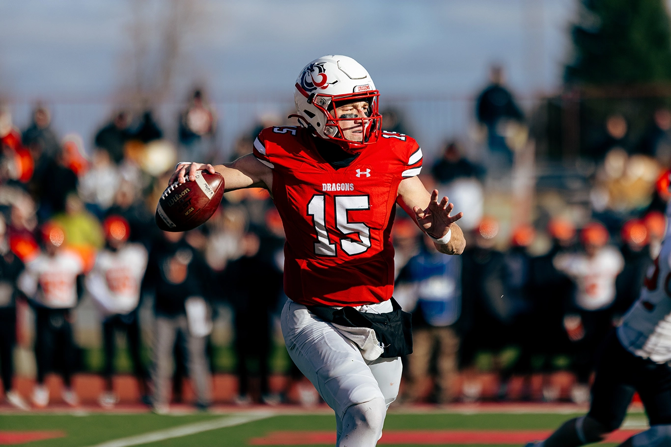 Jack Strand tosses a football on the field.
