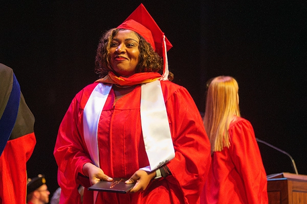Graduate student receiving diploma sleeve at commencement ceremony